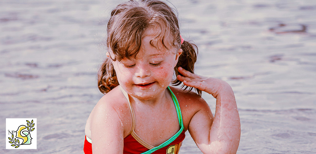 very cute & beautiful down syndrome girl who playing on the beach, near the sea